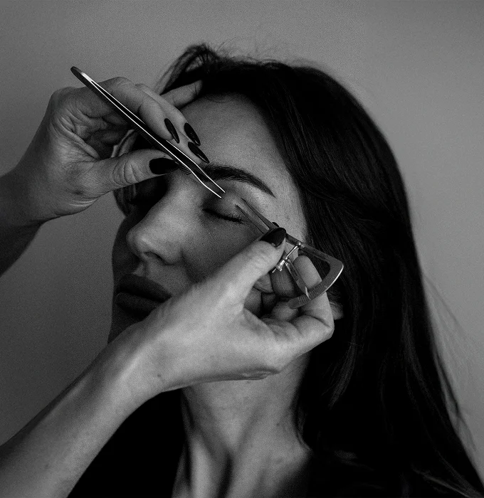 Woman applying mascara with makeup brush in black and white portrait. - Eyelid in Montreal, QC