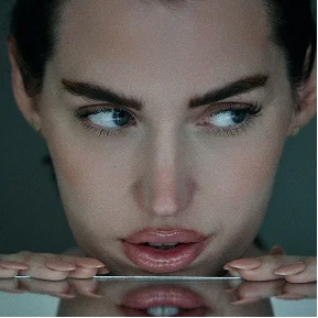 Woman with blue eyes and bold eyebrows gazing at camera with reflection in water below - instagram in Montreal, QC