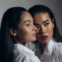 Two women with glowing skin in white shirts showcasing natural beauty and facial aesthetics for biostimulator treatments - Biostimulators in Montreal, QC