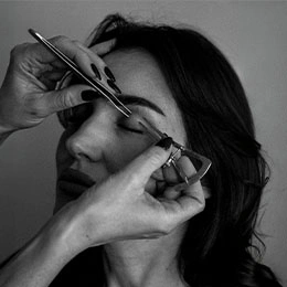 Hands demonstrating eyelid measurement technique with surgical instruments on patient's face in black and white - Upper eyelid surgery in Montreal, QC