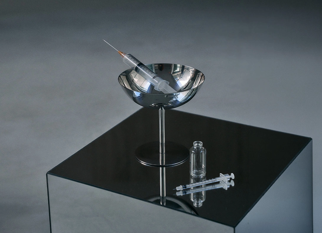 Modern glass laboratory equipment displayed on black pedestal with metallic stand and scientific instruments. - Dermal fillers in Montreal, QC