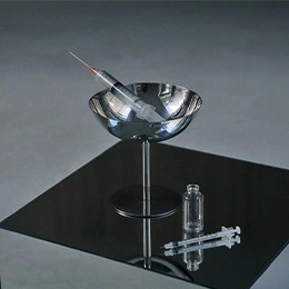 Modern glass bowl vessel sink with chrome faucet on black countertop in contemporary bathroom design - Dermal fillers in Montreal, QC
