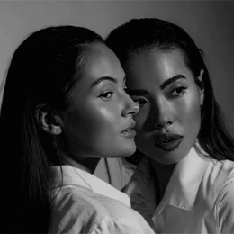 Two women in white shirts pose together in black and white portrait showing facial contours and skin texture - Biostimulators in Montreal, QC