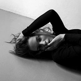 Young woman lying down in black and white portrait showing facial features and profile - Revision rhinoplasty in Montreal, QC