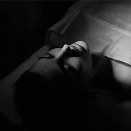 Man lying down before rhinoplasty procedure in black and white artistic photography - Rhinoplasty in Montreal, QC