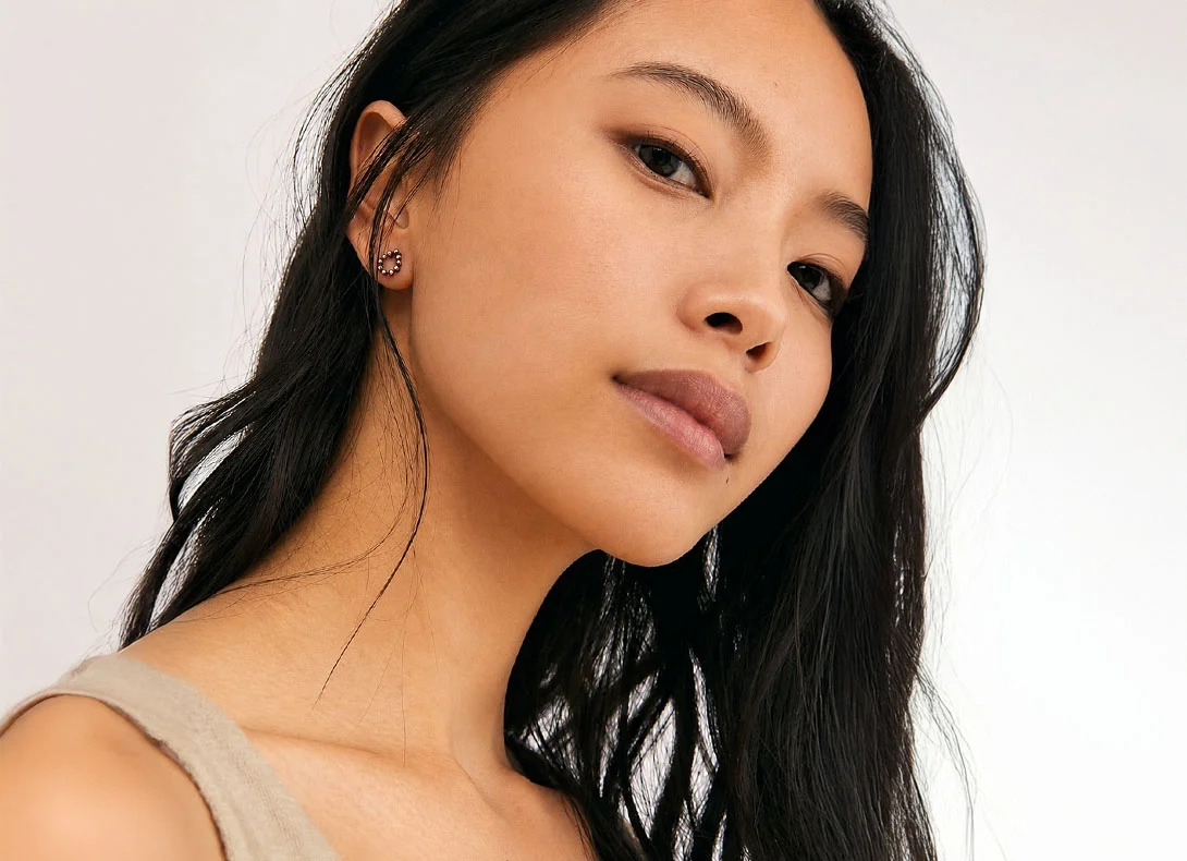 Asian woman with clear smooth skin and natural makeup looking at camera on white background - Acne in Montreal, QC