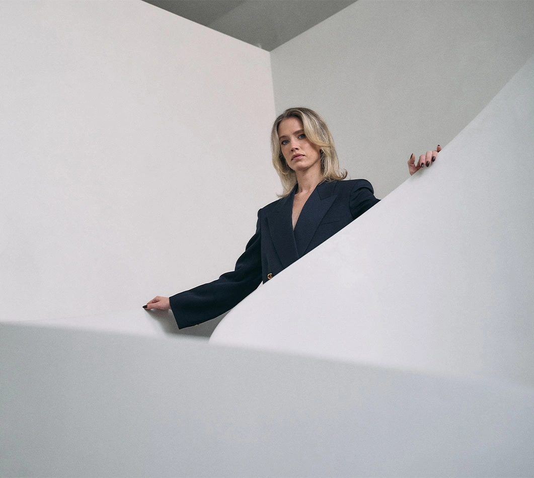Doctor Emily Deane MD wearing a black blazer and walking down stairs. - Deane in Montreal, QC