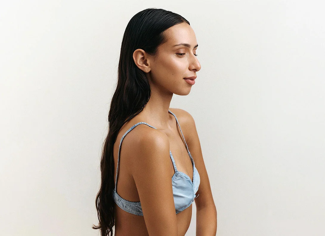 Woman in profile showing long healthy dark hair against white background for hair loss article - Hairloss in Montreal, QC