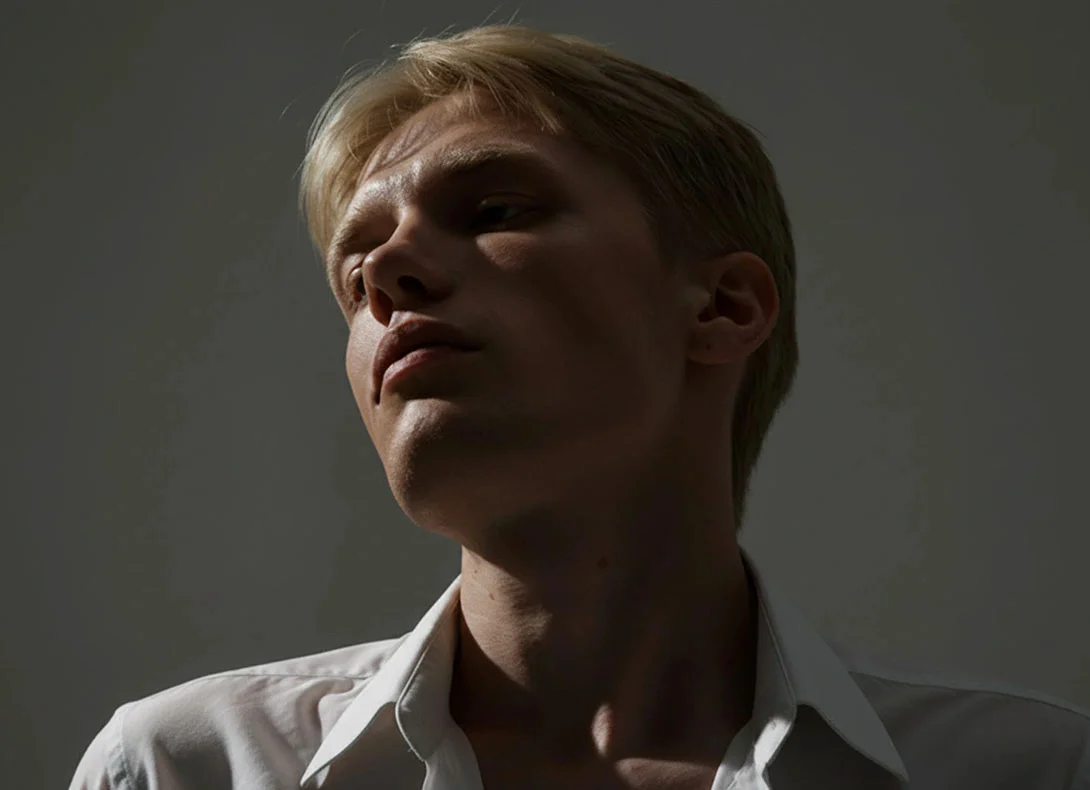 Young man with refined nose profile in natural lighting showing post-rhinoplasty results - Male rhinoplasty in Montreal, QC